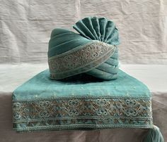 a green hat sitting on top of a blue blanket next to a tasseled headband