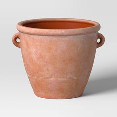 a large clay pot with handles on the top and bottom, sitting in front of a white background