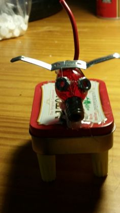 a red and black toy airplane on top of a wooden table