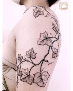 a woman's arm with vines and leaves tattoo on the left side of her body