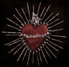 a red heart surrounded by silver pins