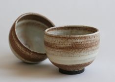 two brown and white bowls sitting next to each other