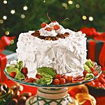 a large white cake sitting on top of a glass plate next to christmas decorations and presents