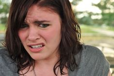 a close up of a person with a surprised look on their face and necklaces