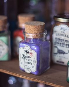 some jars are sitting on a shelf with different types of spices in them and one has a brown cork top