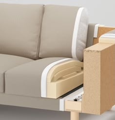 a close up of a couch with a drawer in front of it and an open box on the back