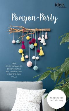 a blue wall with pompon - party decorations hanging from it