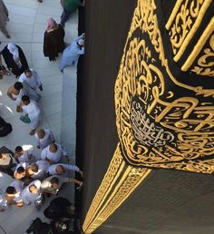 a group of people standing next to each other in front of a black and gold structure