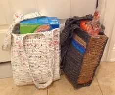 two crocheted bags sitting next to each other on the floor in front of a door