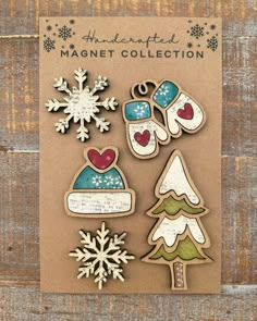 magnets with snowflakes, trees and mittens are on top of a piece of paper