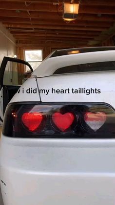 a white car with two red hearts on it's tail lights and the words, i did my heart taillights