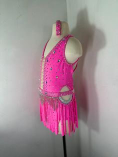 a mannequin wearing a bright pink dress with sequins and fringes