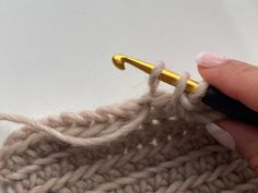 someone is crocheting the ends of a sweater with a knitting needle on it