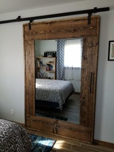 a bedroom with a bed and mirror in it