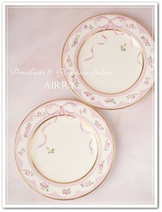 two pink and white plates with gold trims on the sides, one is empty