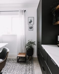 a bath room with a tub a sink and a rug on the floor in front of a window