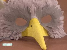 a yellow and gray bird mask sitting on top of a table