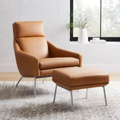 a brown chair and ottoman in front of a window