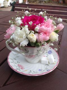 a tea cup filled with pink and white flowers