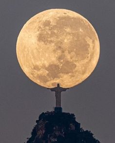 a cross on top of a hill with the moon in the background