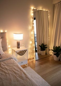 a bedroom with lights on the walls and a bed in front of a large mirror