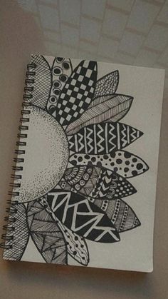 a spiral notebook with black and white designs on it