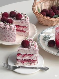 two pieces of cake with raspberry frosting and fresh berries on the top