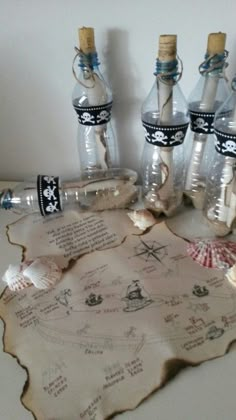 several bottles with writing on them sitting on a table next to shells and seashells