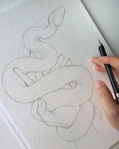 someone is drawing a snake on paper with a pencil