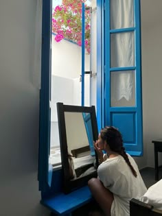 a woman sitting in front of a mirror