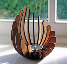 a wooden sculpture made to look like a bird's wing with a candle holder in the middle