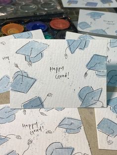 some blue graduation caps are on top of white paper with words happy grad written in black ink