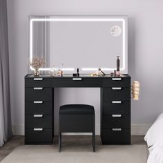 a black vanity with lighted mirror and stool