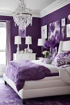 a purple and white bedroom with chandelier above the bed, pictures on the wall