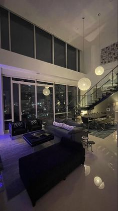 a living room filled with furniture and lots of windows next to a stair case in front of a large window