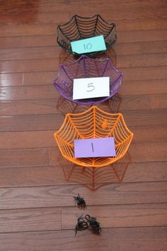 three different colored wire baskets sitting on top of a wooden floor