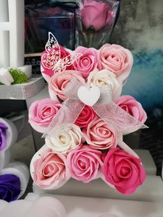 a bouquet of pink and white roses with a butterfly on top