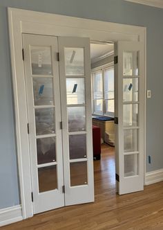 an empty room with three glass doors and hard wood flooring on the wooden floor