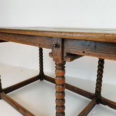 an old wooden table with turned down legs