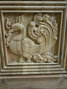 an intricately carved wood panel depicting a rooster