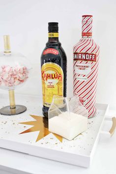 the ingredients to make this holiday drink are displayed on a white tray with red and gold confetti