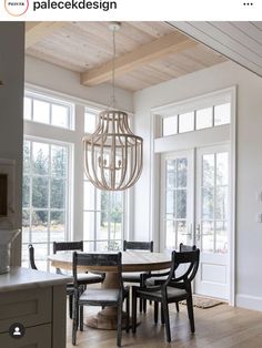 a dining room table with chairs and a chandelier hanging from it's ceiling