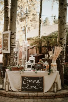 there is a sign that says smeree and love on the table in front of some trees