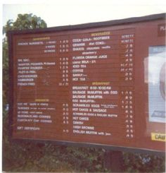 a large sign with many different languages and numbers on it's side in front of some trees