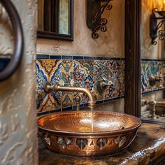 a copper sink in a bathroom with ornate tile on the walls and below it is a mirror