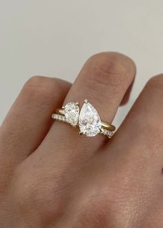 a woman's hand with three pear shaped diamonds on top of her finger,