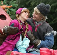 two people sitting on top of a bench next to each other in winter clothing and hats