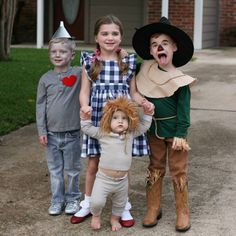 three children dressed up as scarecrows posing for the camera