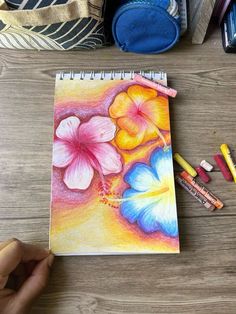 a person is drawing flowers with colored pencils