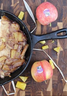 an apple and pork roast in a skillet on a cutting board next to sliced apples